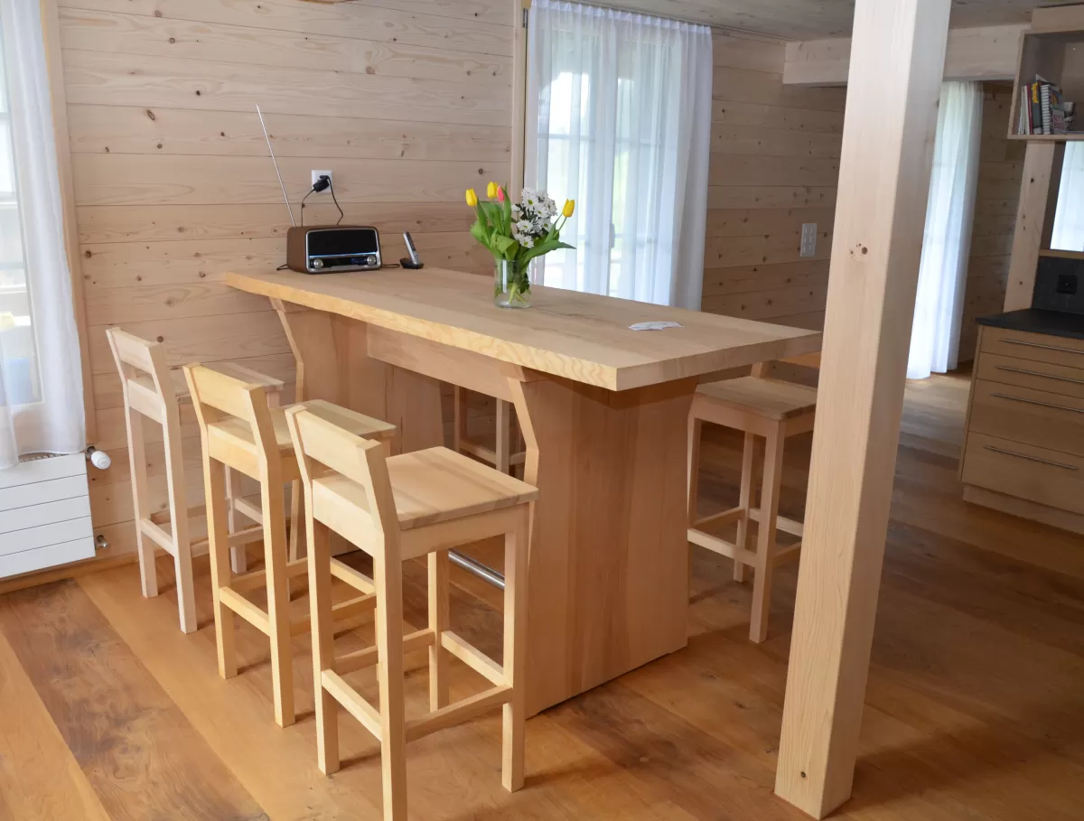 Der Tisch hat ein Eschenblatt das so gross wie der Holzstamm war. Der Holzstamm stammt aus einem verwandten Wald. Der Bar-Tisch ist mit seinem einzigartigem Tischblatt eine Augenweide.