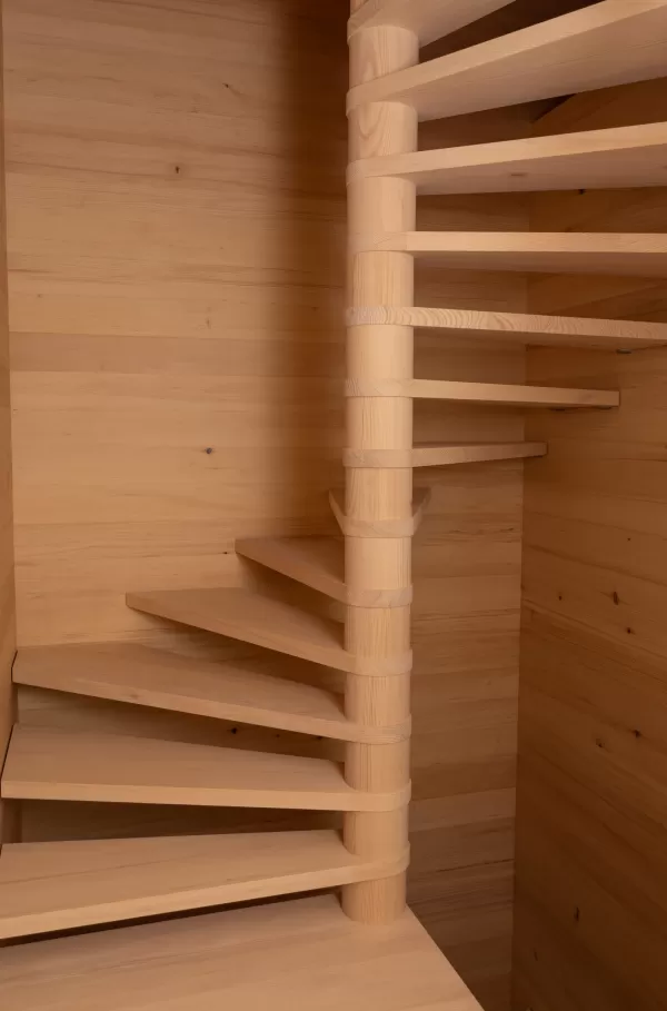 Detailaufnahme einer hellen Holz-Spindeltreppe mit geschwungenen Stufen in einem holzverkleideten Innenraum
