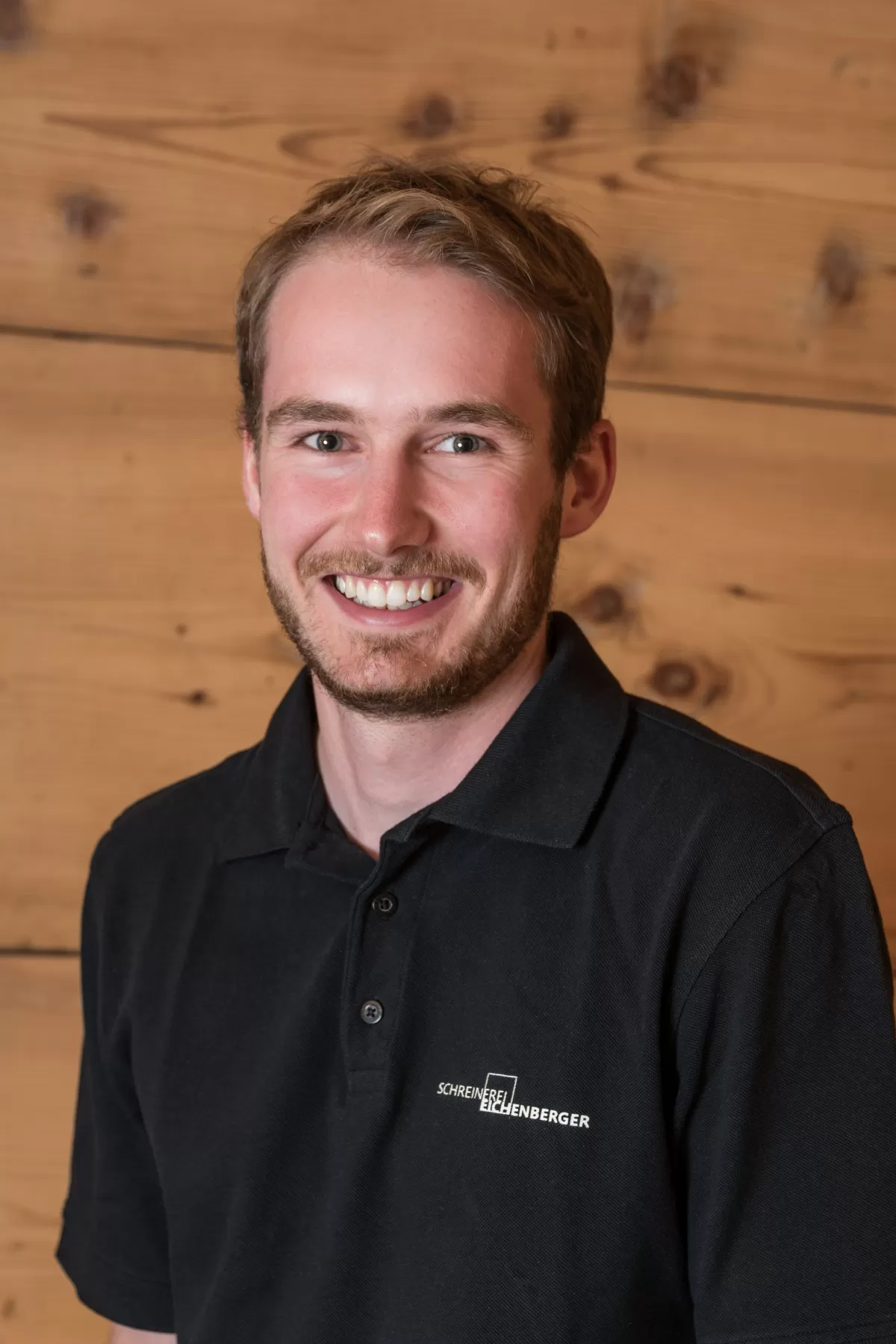 Bucher Jan von Hasle mit einem schwarzen Polo Shirt mit der Anschrift Schreinerei Eichenberger