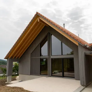 Einfamilienhaus Truberholzhaus, vergraute Aussenschalung, Ziegel, Fensterfront